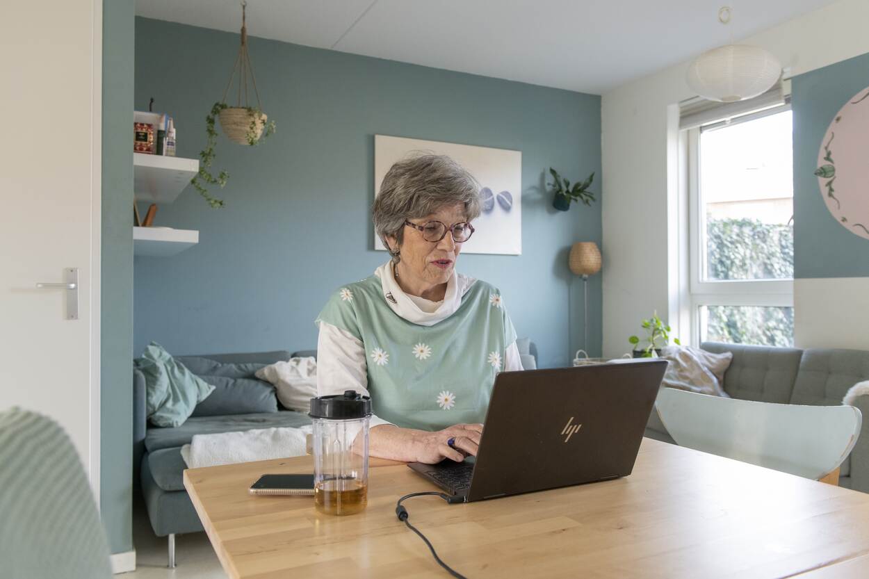 Een vrouw zit voor een laptop